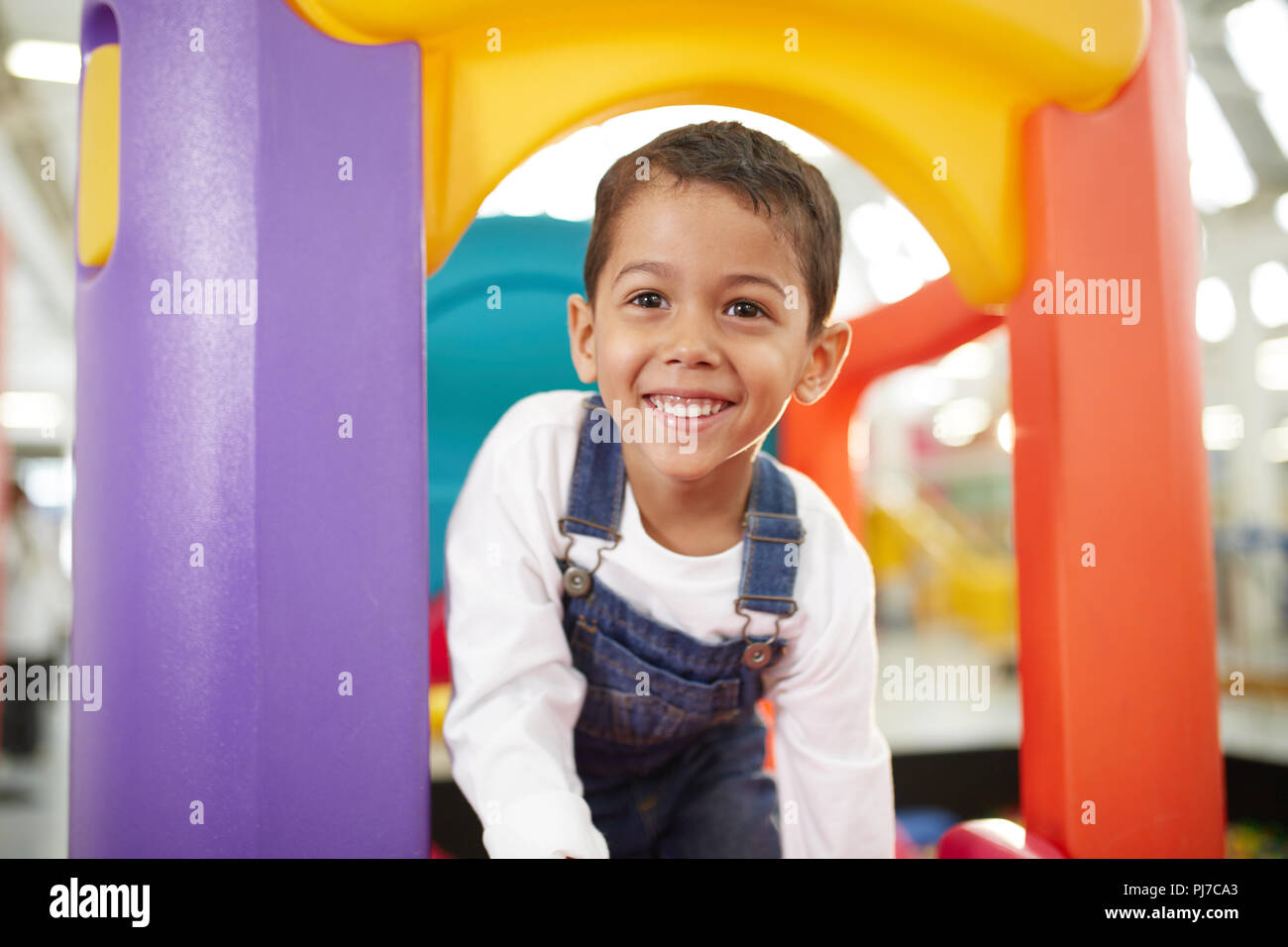 Portrait of cute boy playing on slide Banque D'Images