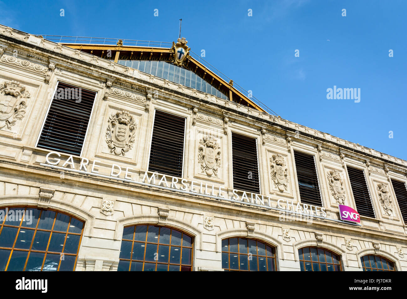 La façade de la gare Saint-Charles à Marseille, France, avec le nom de la station et le logo de la SNCF dans le cadre de l'Armoiries des villes desservies. Banque D'Images