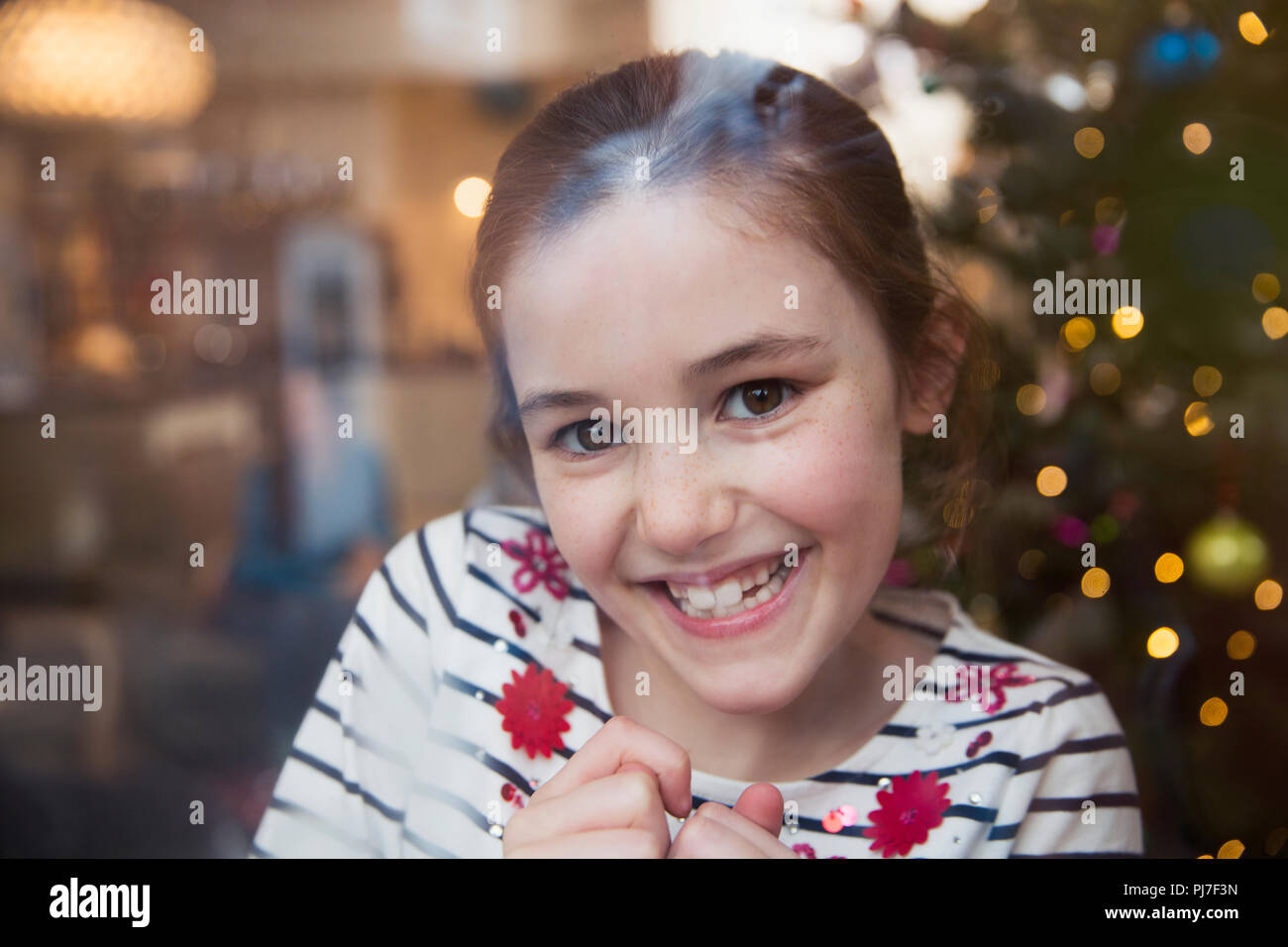 Portrait souriant, confiant fille dans un salon de Noël Banque D'Images