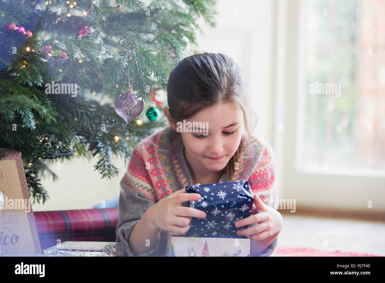 Curieux girl holding Christmas Gift Banque D'Images