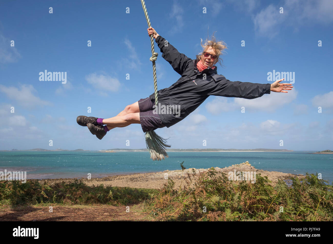 Woman on Rope Swing ; St Mary's, Îles Scilly ; UK Banque D'Images