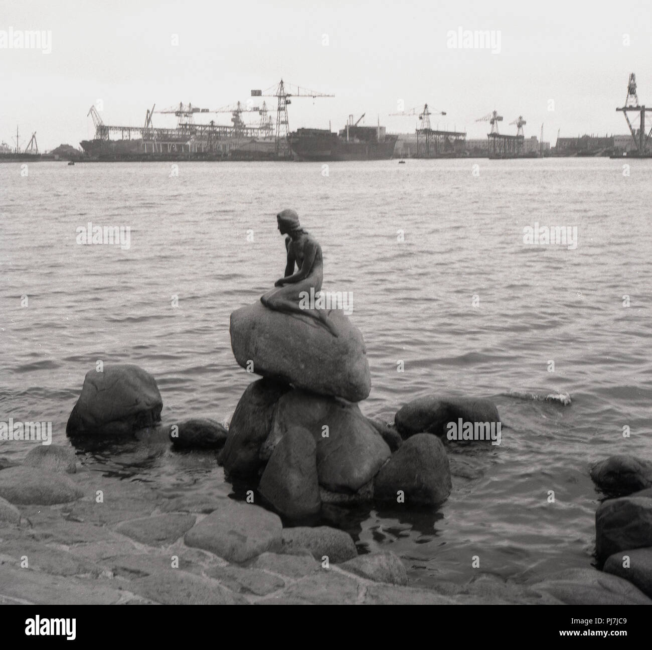 Années 1950, historiques, la statue de bronze, 'La Petite Sirène', sur un rocher au bord de l'eau à Langelinie, Copenhague, Danemark. Cette petite et unimposing statue d'Edvard Eriksen a été dévoilé dansdans 1913 et est devenu une icône de la ville, Banque D'Images