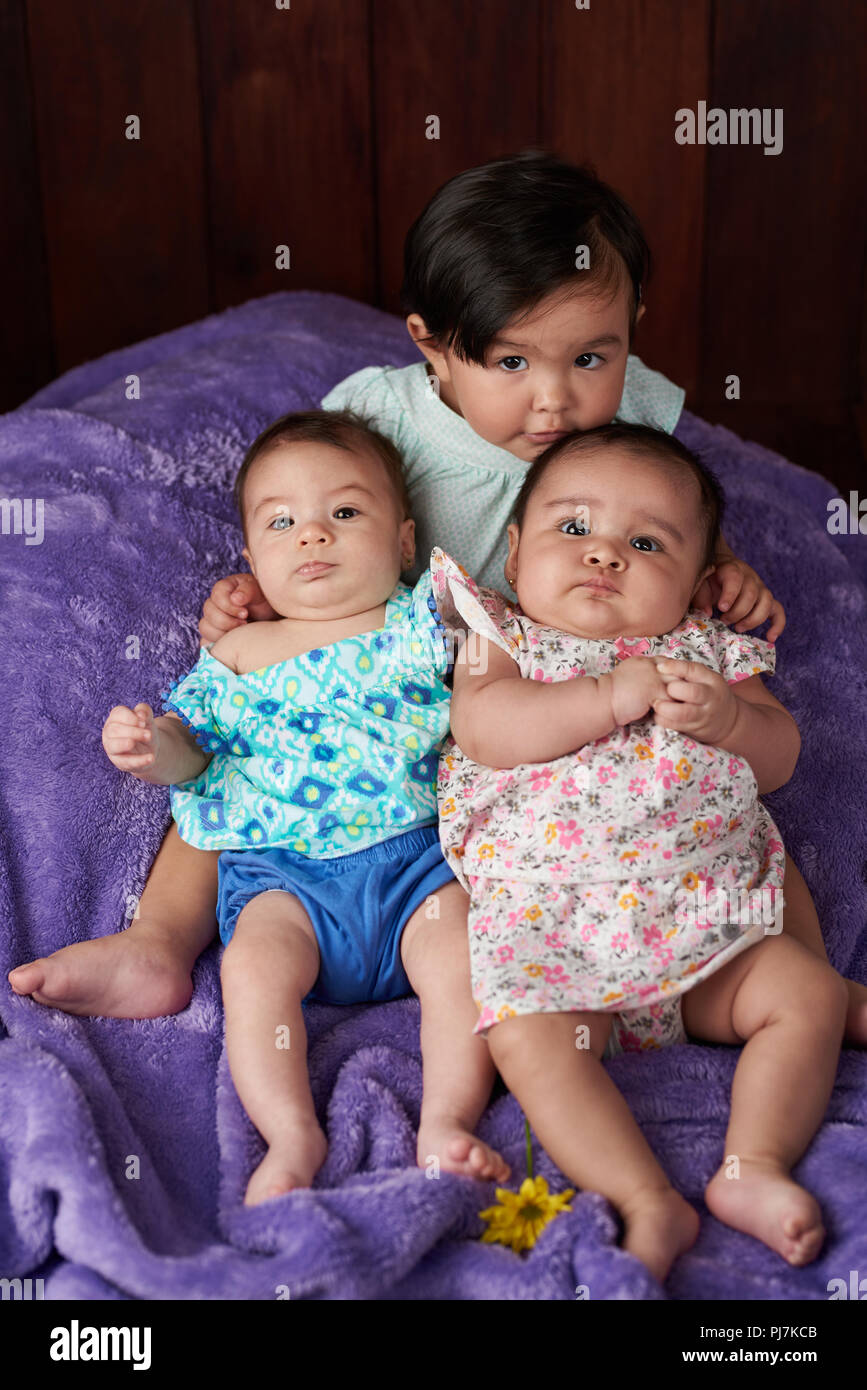 Portrait de petit groupe bébés sur fond de studio en bois Banque D'Images