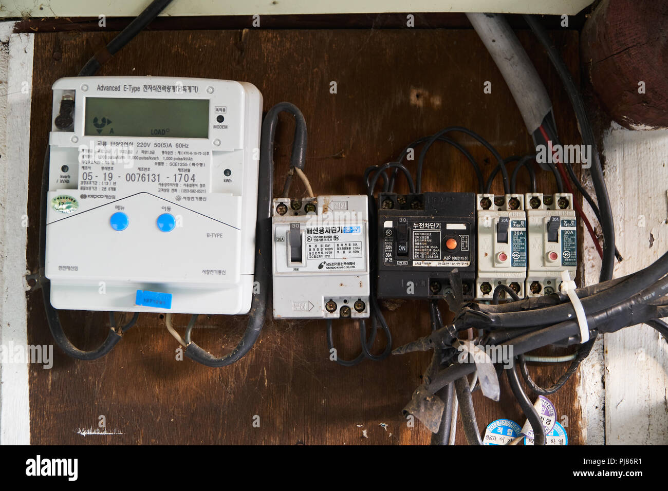 Des armes d'inje, CORÉE - 10 mai 2018 : vieux câbles, disjoncteur et compteurs électriques intelligents numérique installé sur une planche en bois de vieille maison en Corée. Banque D'Images Des armes d'inje, CORÉE - 10 mai 2018 : vieux câbles, disjoncteur et compteurs électriques intelligents numérique installé sur une planche en bois de vieille maison en Corée. Banque D'Images