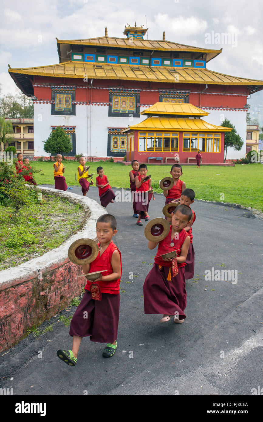 Gangtok, Inde - Mai 3, 2017 : jeune novice moines bouddhistes en robe rouge traditionnelle pratiquant en jouant des instruments de musique tingsha Tibétaines Banque D'Images