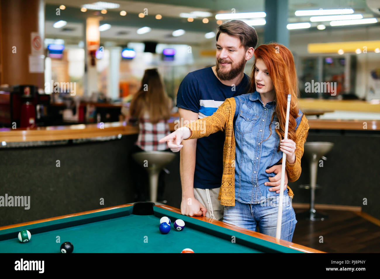 Beautiful couple playing billiards Banque D'Images