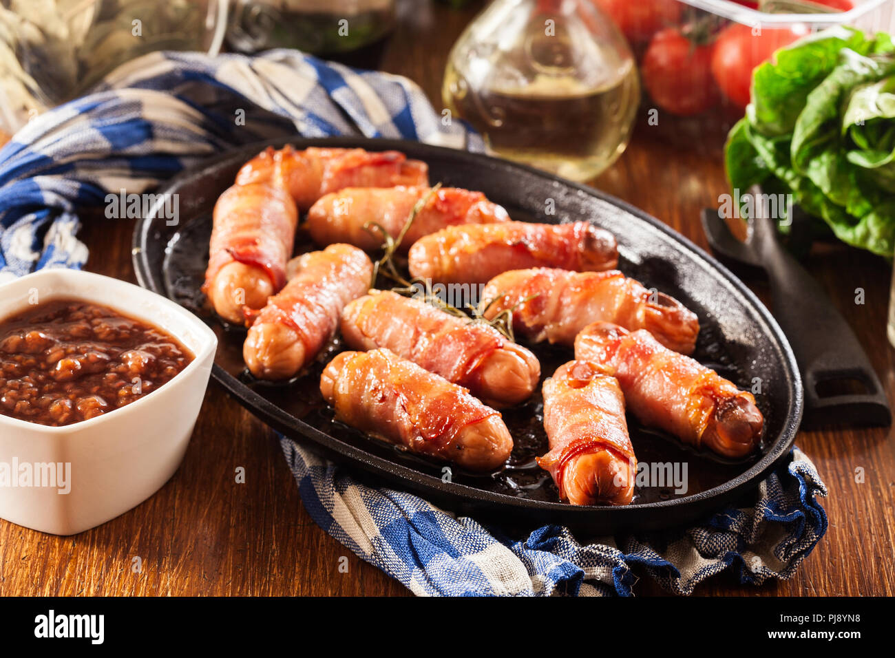 Les porcs dans des couvertures. Mini saucissons enveloppés dans du bacon fumé dans le plat de cuisson Banque D'Images