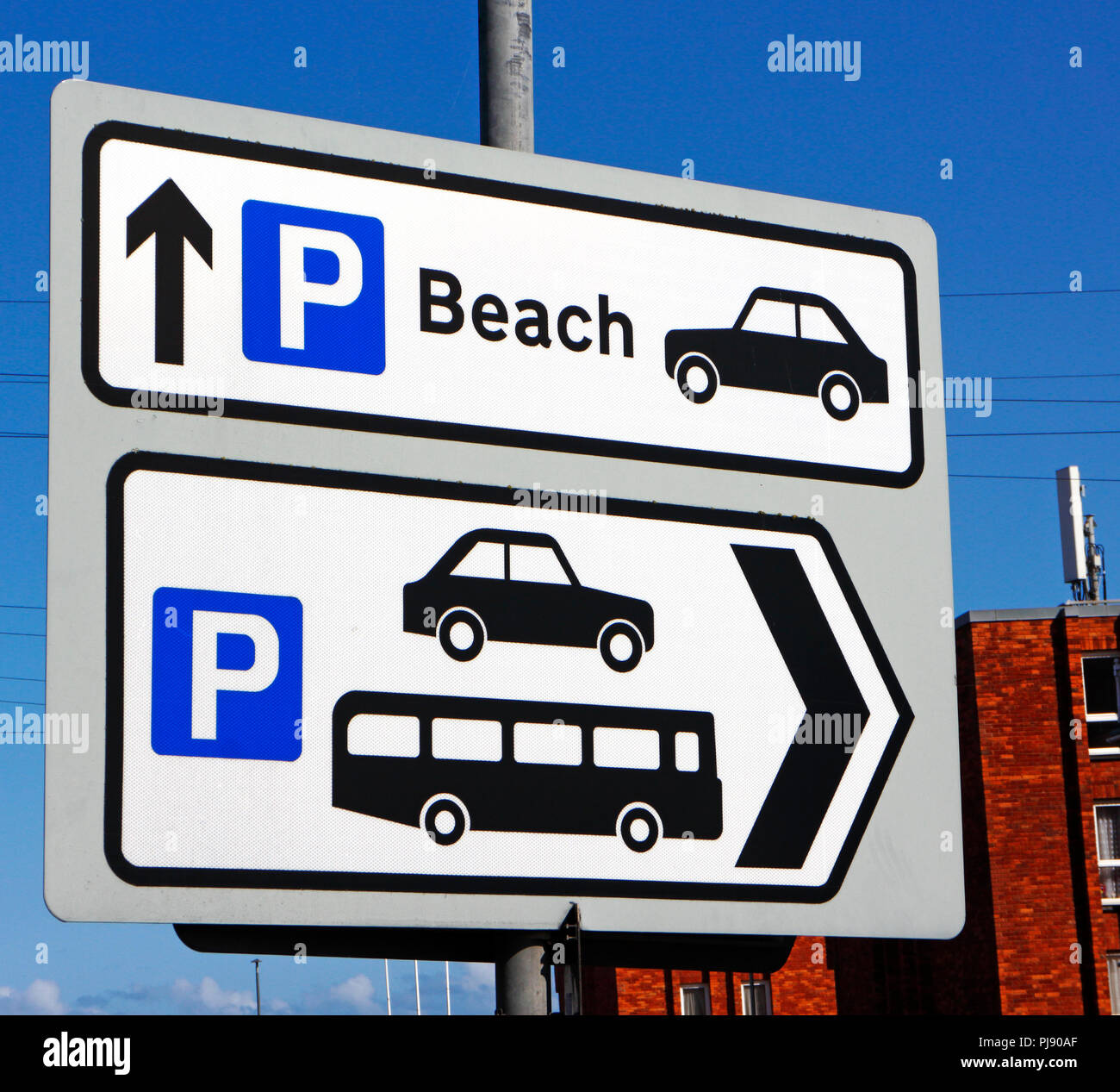 Panneau routier avec des directions pour le parking de la plage et du centre-ville, parking pour voitures et autocars à Cromer, Norfolk, Angleterre, Royaume-Uni, Europe. Banque D'Images