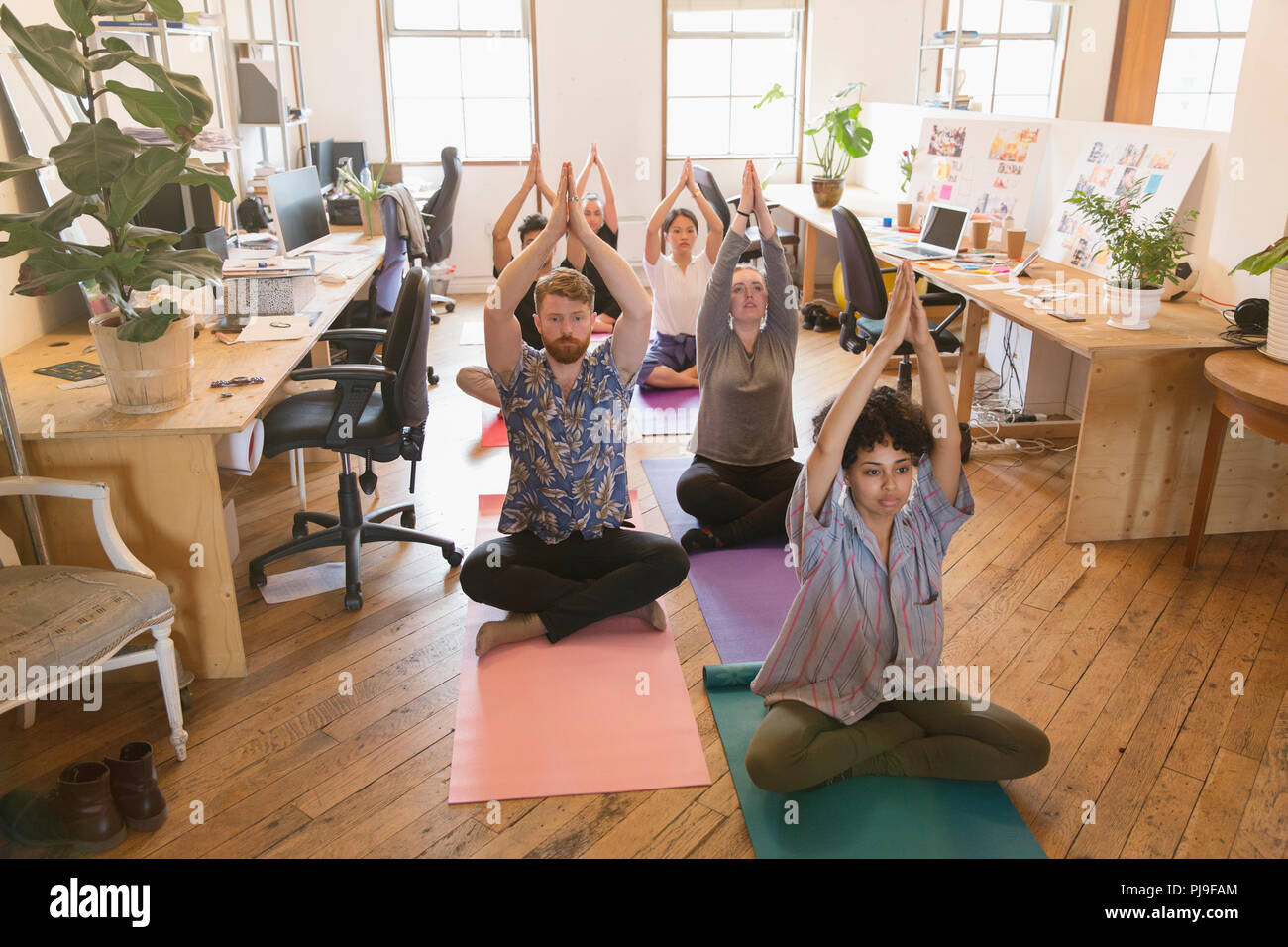 Creative business people practicing yoga in office Banque D'Images