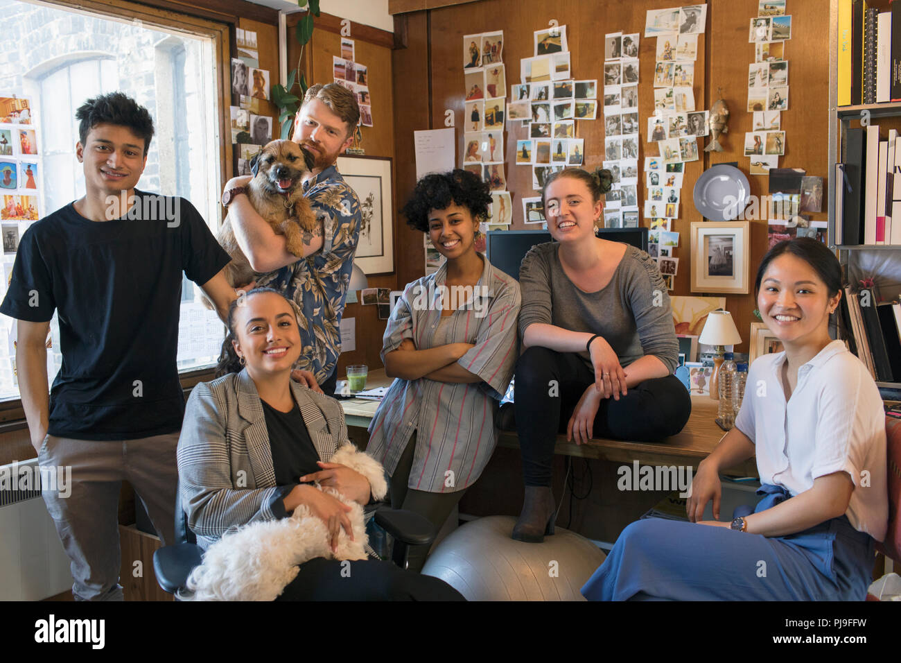 Portrait confiant concepteurs créatifs avec les chiens in office Banque D'Images