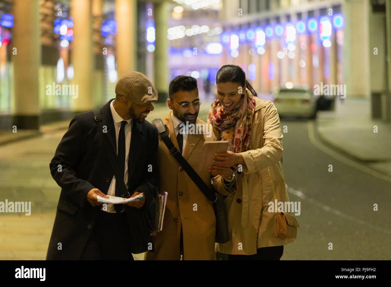 Business people on urban street at night Banque D'Images