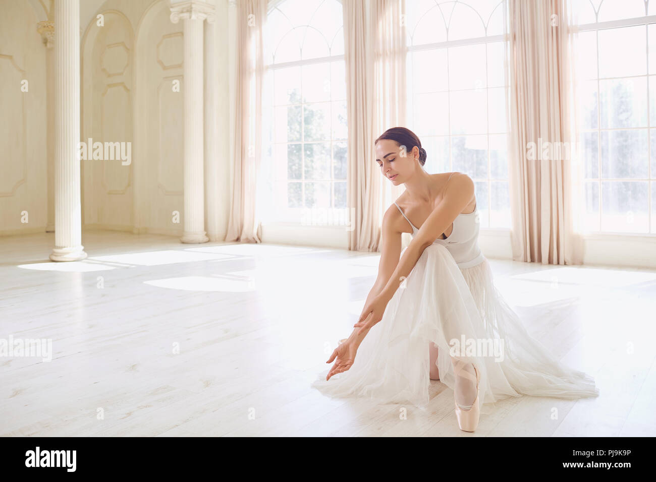 Une ballerine en blanc dans un livre blanc studio. Banque D'Images