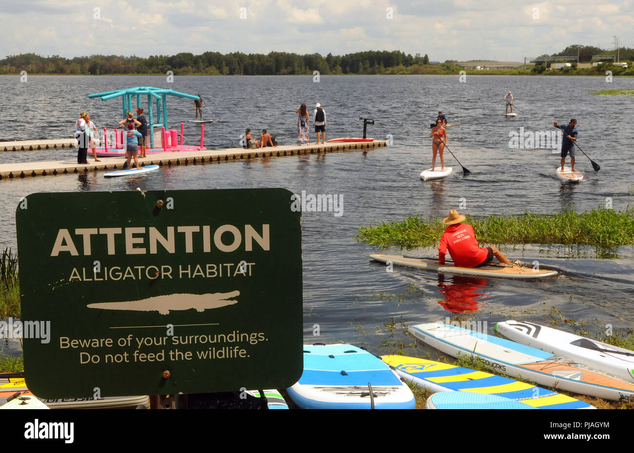 Orlando, Floride, USA. 5 septembre 2018 - Orlando, Floride, États-Unis - Personnes ride paddle boards près d'un alligator panneau d'avertissement à la Surf Expo le 5 septembre 2018 à Bill Frederick Park at Turkey Lake à Orlando, Floride. (Paul Hennessy/Alamy) Crédit : Paul Hennessy/Alamy Live News Banque D'Images