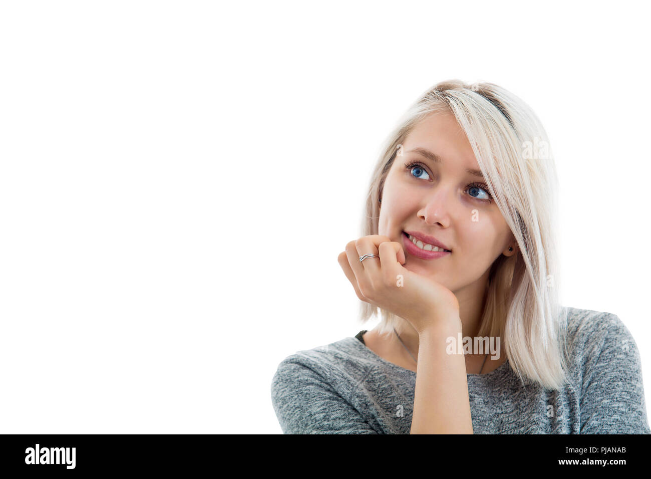 L'horizontale portrait of cute jeune femme avec des yeux bleus et doux  sourire tenant la main sous le menton à heureux et insouciant. Jolie femme  gaie Photo Stock - Alamy