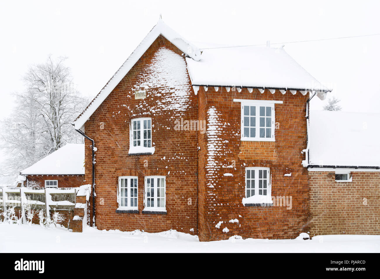 Ancienne maison victorienne avec toit et murs en brique recouverts de neige en hiver Banque D'Images