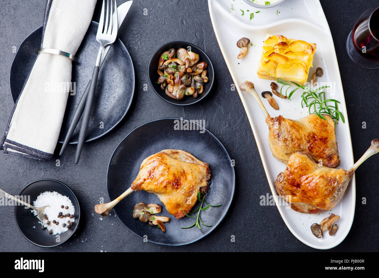 Les cuisses de canard confit au gratin de pommes de terre et sauce aux champignons. Restaurant. Vue d'en haut. Banque D'Images