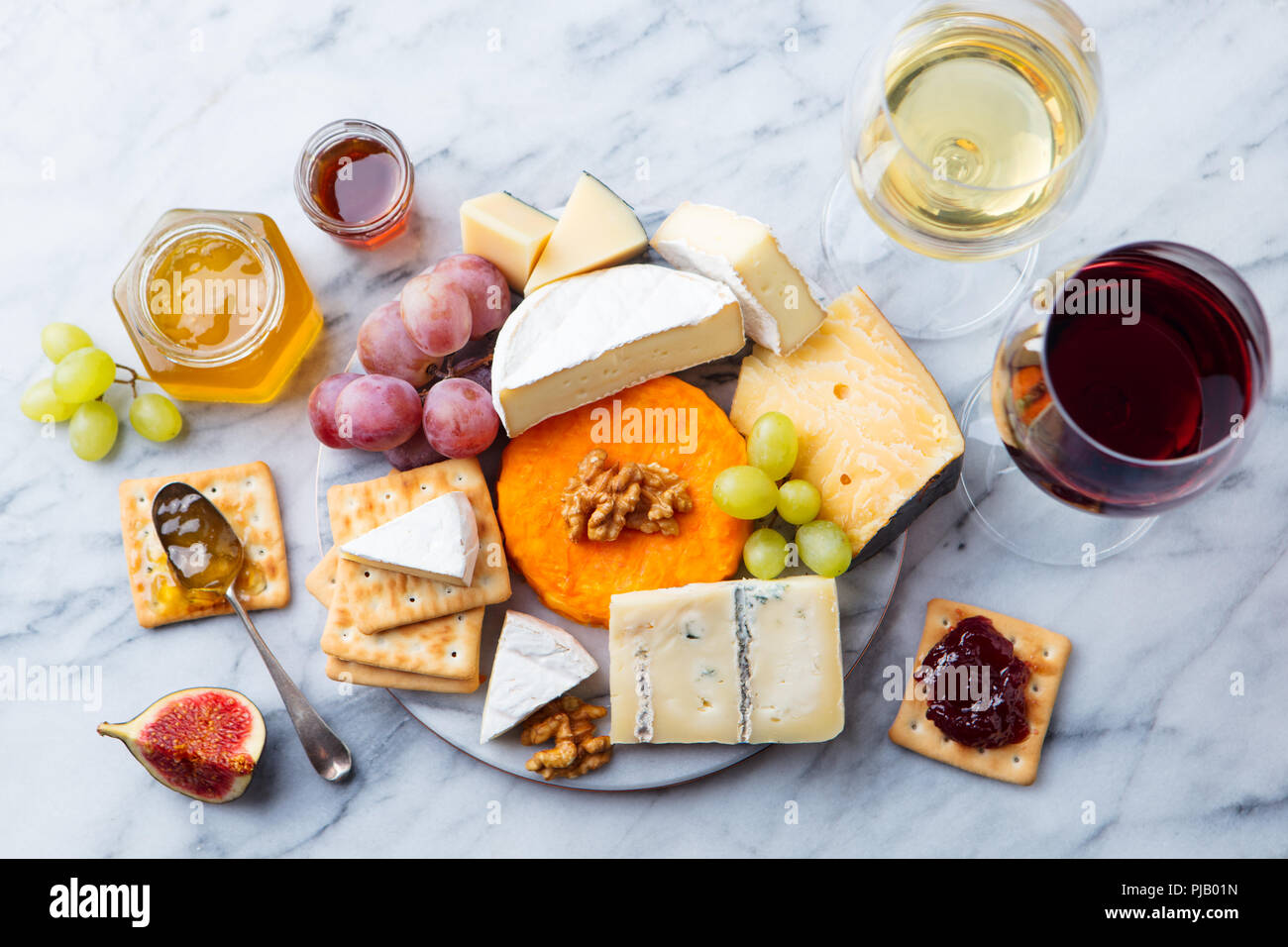 Assortiment de fromages, raisins à vin rouge et blanc dans les verres. En arrière-plan. Vue d'en haut. Banque D'Images