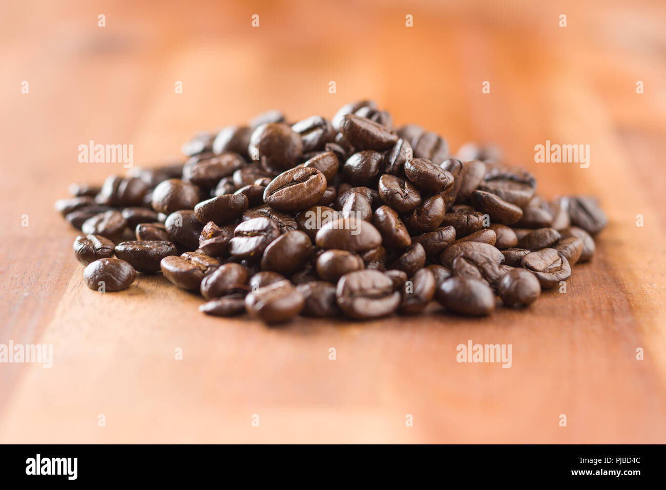 Les grains de café torréfiés sur table en bois. Banque D'Images