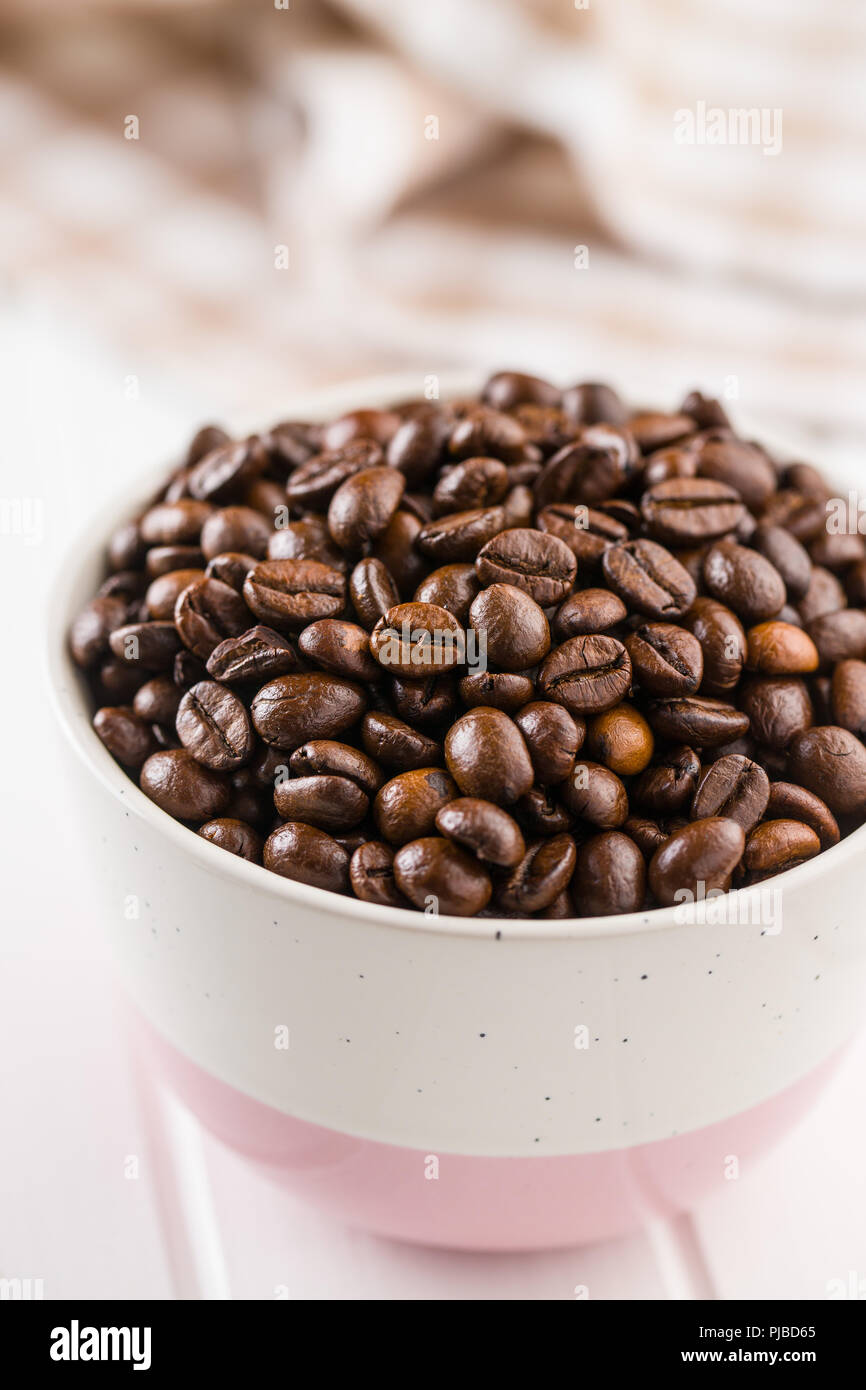 Les grains de café torréfiés dans un bol. Banque D'Images