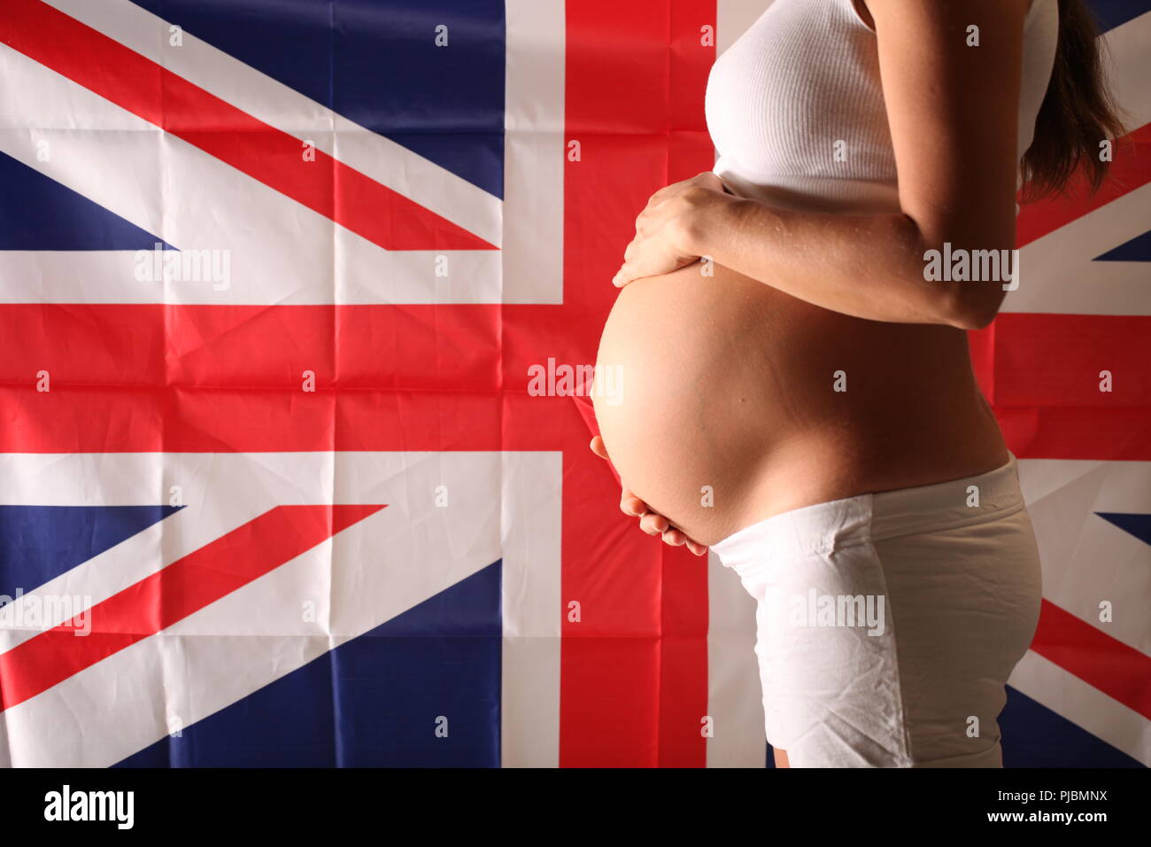 La fécondité dans le Royaume-Uni concept d'une fille enceinte et drapeau anglais Banque D'Images