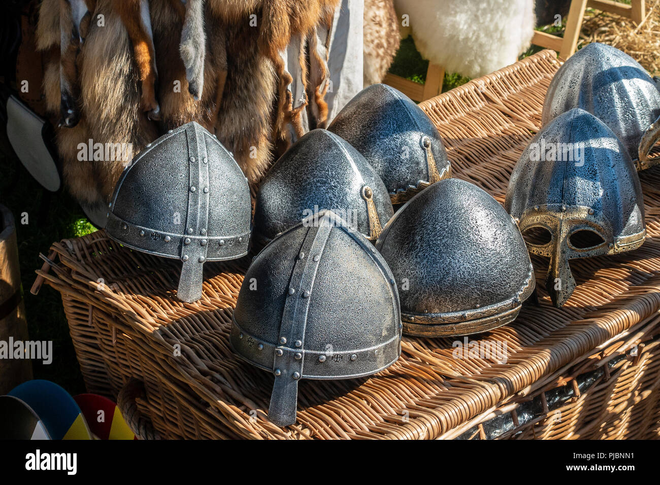 Une gamme de casques de style Viking metal d'une exposition-vente dans le village viking à Largs Viking Festival, avec quelques peaux d'animaux. Banque D'Images