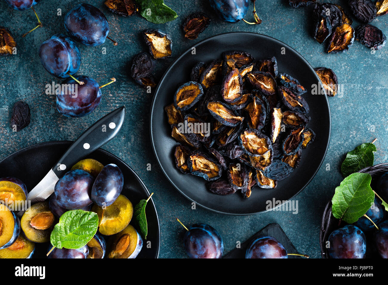 Pruneaux et prunes fraîches avec des feuilles Banque D'Images