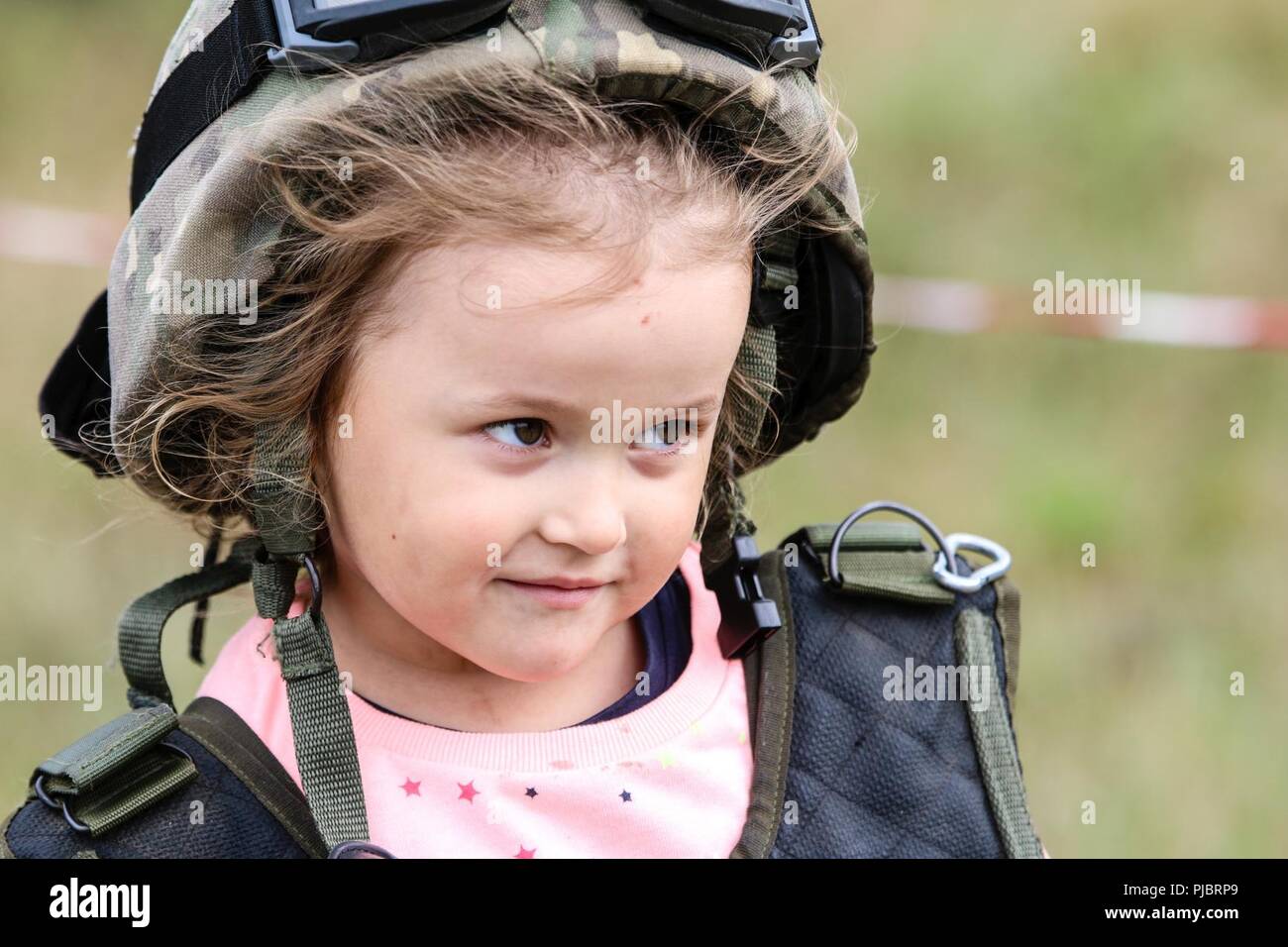 Un enfant essaie sur l'équipement militaire de l'Armée roumaine de l'artillerie de défense aérienne du bleu "Scorpions" au cours d'une présentation statique de l'équipe polonaise 15e Brigade mécanisée du réservoir d'une célébration de la Bataille de Pologne Groupe Orzysz, Pologne le 14 juillet 2018. La Pologne est un groupe de combat, unique coalition multinationale d'États-Unis, Royaume-Uni, croate et soldats roumains qui servent avec la 15e Brigade mécanisée polonaise comme une force de dissuasion de l'OTAN à l'appui de l'amélioration de l'avant la Présence. Banque D'Images