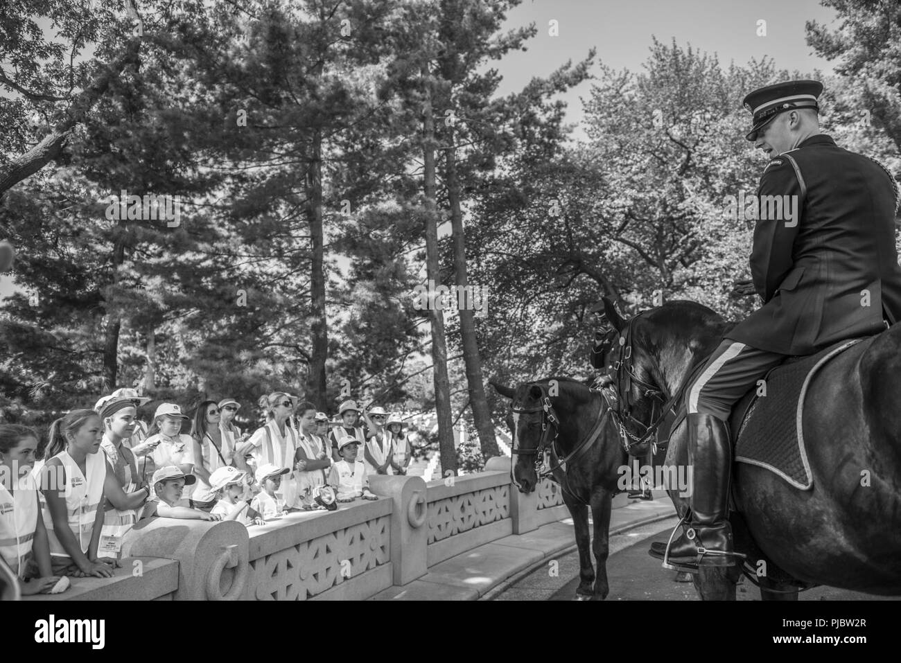 La CPS de l'armée américaine. Justin d'équipages des États-unis 3d (Régiment d'infanterie de la vieille garde) Peloton Caisson des entretiens avec les enfants bénévoles à côté de l'USS Maine Monument à l'article 46 du Cimetière National d'Arlington, Arlington, Virginie, le 16 juillet 2018. Plus de 400 professionnels ont participé à paysage bénévole l'Association nationale des professionnels du paysage et de renouvellement annuel des 22e événement du Souvenir au Cimetière National d'Arlington. Le gazon, les bénévoles plantés de fleurs, mis des tuyaux d'irrigation, et la protection de l'éclairage installé sur plusieurs arbres. Banque D'Images