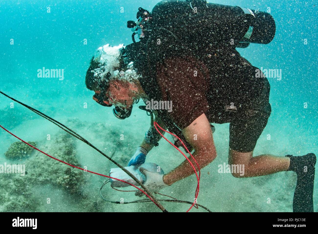 MAMALA BAY, Hawaii (19 juillet 2018) Construction Mécanicien 3e classe Lucas Jackson, attribué à l'équipe de construction sous-marine (UCT) 2, place une charge explosive sur le plancher océanique au cours des travaux de démolition sous-marine dans la baie pendant la formation Mamala Rim of the Pacific (RIMPAC), le 19 juillet. Vingt-cinq nations, 46 navires, 5 sous-marins, environ 200 avions et 25 000 personnes participent à l'EXERCICE RIMPAC du 27 juin au 2 août dans et autour des îles Hawaï et la Californie du Sud. Le plus grand exercice maritime international RIMPAC, fournit une formation unique tout en renforçant et en Banque D'Images