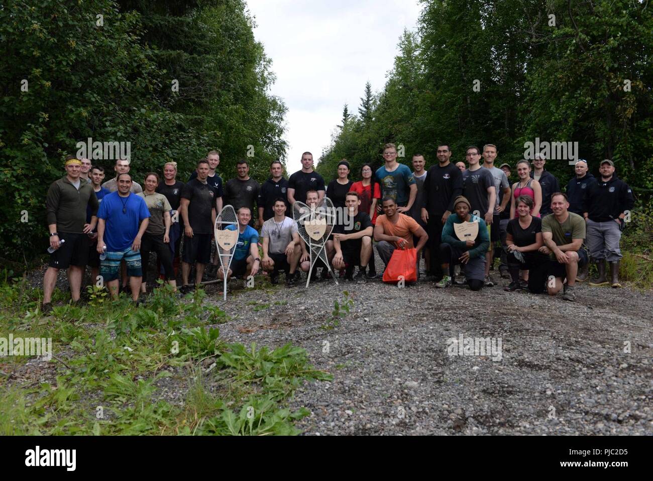 Les participants à la survie de l'Arctique 2018 5k Mud Run posent à la ligne d'arrivée de la course, le 16 juillet 2018 à Eielson Air Force Base, en Alaska. Les participants ont signé jusqu'à des équipes de quatre pour terminer la sur-sous, Spider web, de boue, ramper, et connectez-vous transporter des défis. Banque D'Images