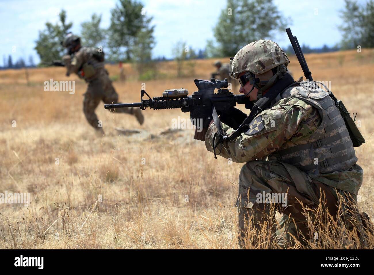 Le s.. Taylor Anderson, chef d'équipe, Alpha Co., 3e bataillon du 161e Régiment d'infanterie, couvre-feu pour le Sgt. Jeremy Tan lors d'un exercice tactique de l'équipe lane le 20 juillet, 2018 at Joint Base Lewis-McChord. 3e bataillon effectue actuellement une formation annuelle de trois semaines. (US National Guard Banque D'Images