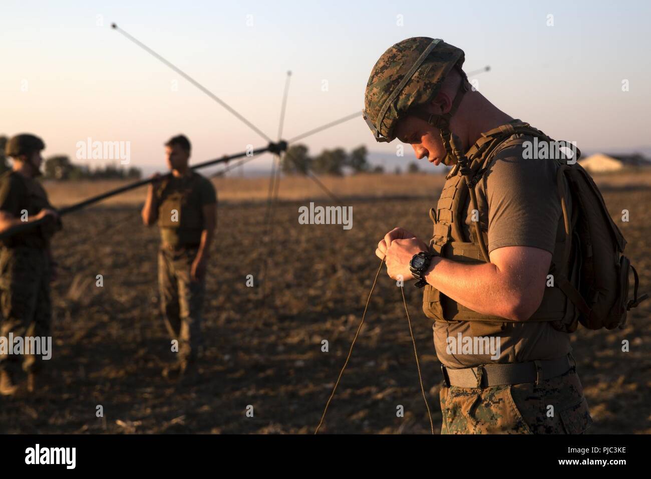 Une Aire Marine affectés à des fins de travail air-sol marin Force-Crisis Sud, la logistique de l'élément de combat 18.2, prépare un hauban à l'appui d'une antenne radio, à la base aéronavale de Sigonella, 11 juillet 2018. Les marines mis en place et testé un BE-254 antenne radio et pratiqué l'étiquette radio appropriée lors de l'utilisation d'un PRC 152 radio sur de très hautes fréquences. La formation a pour but d'assurer que tous les Marines ont été adéquatement formés dans la région de base en communication et prêt à utiliser les connaissances sur l'Examen de compétences en combat. Banque D'Images