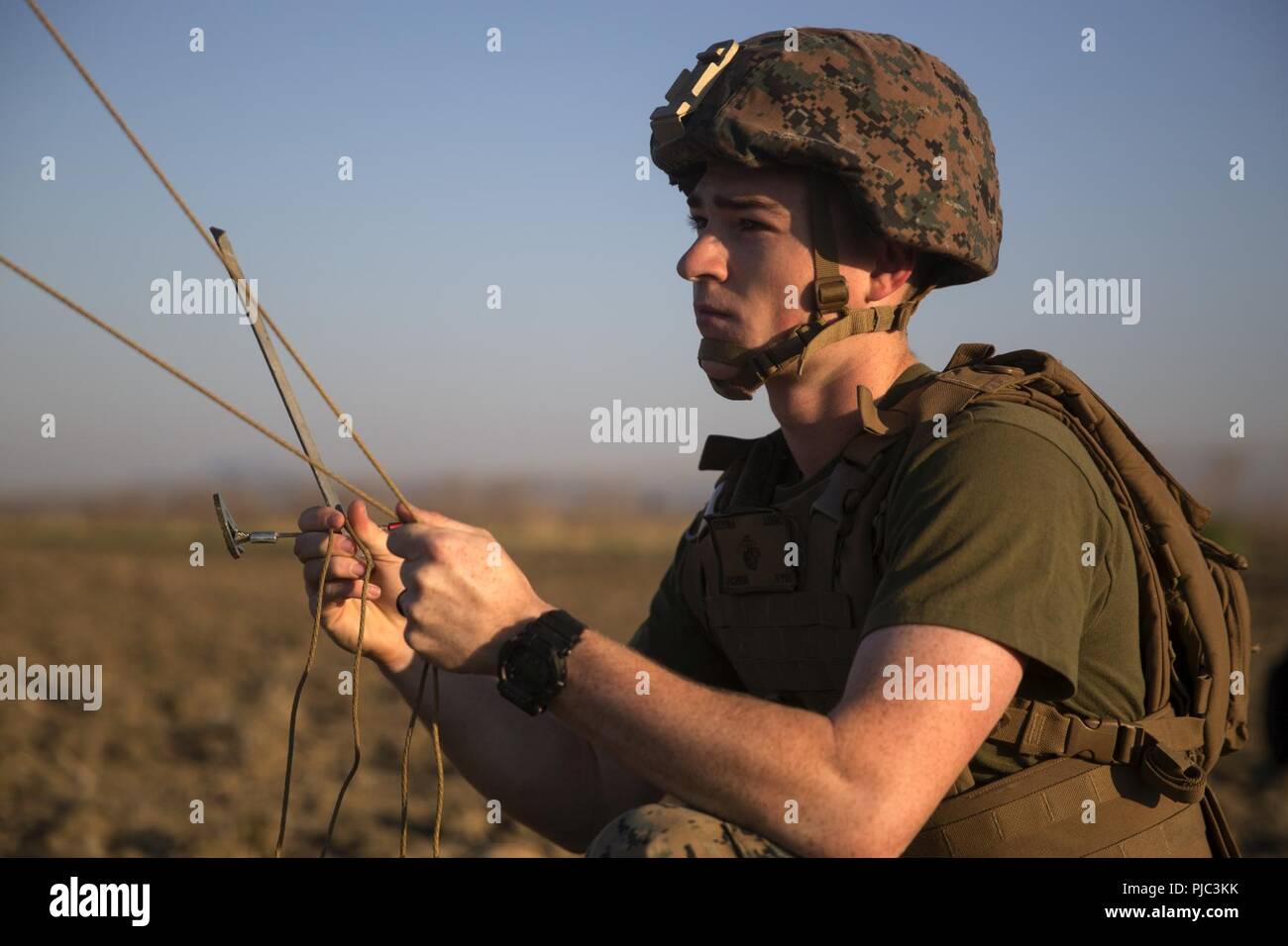 Une Aire Marine affectés à des fins de travail air-sol marin Force-Crisis Sud, la logistique de l'élément de combat 18.2, se prépare à cause d'un hauban pour une antenne radio, à la base aéronavale de Sigonella, 11 juillet 2018. Les marines mis en place et testé un BE-254 antenne radio et pratiqué l'étiquette radio appropriée lors de l'utilisation d'un PRC 152 radio sur de très hautes fréquences. La formation a pour but d'assurer que tous les Marines ont été adéquatement formés dans la région de base en communication et prêt à utiliser les connaissances sur l'Examen de compétences en combat. Banque D'Images