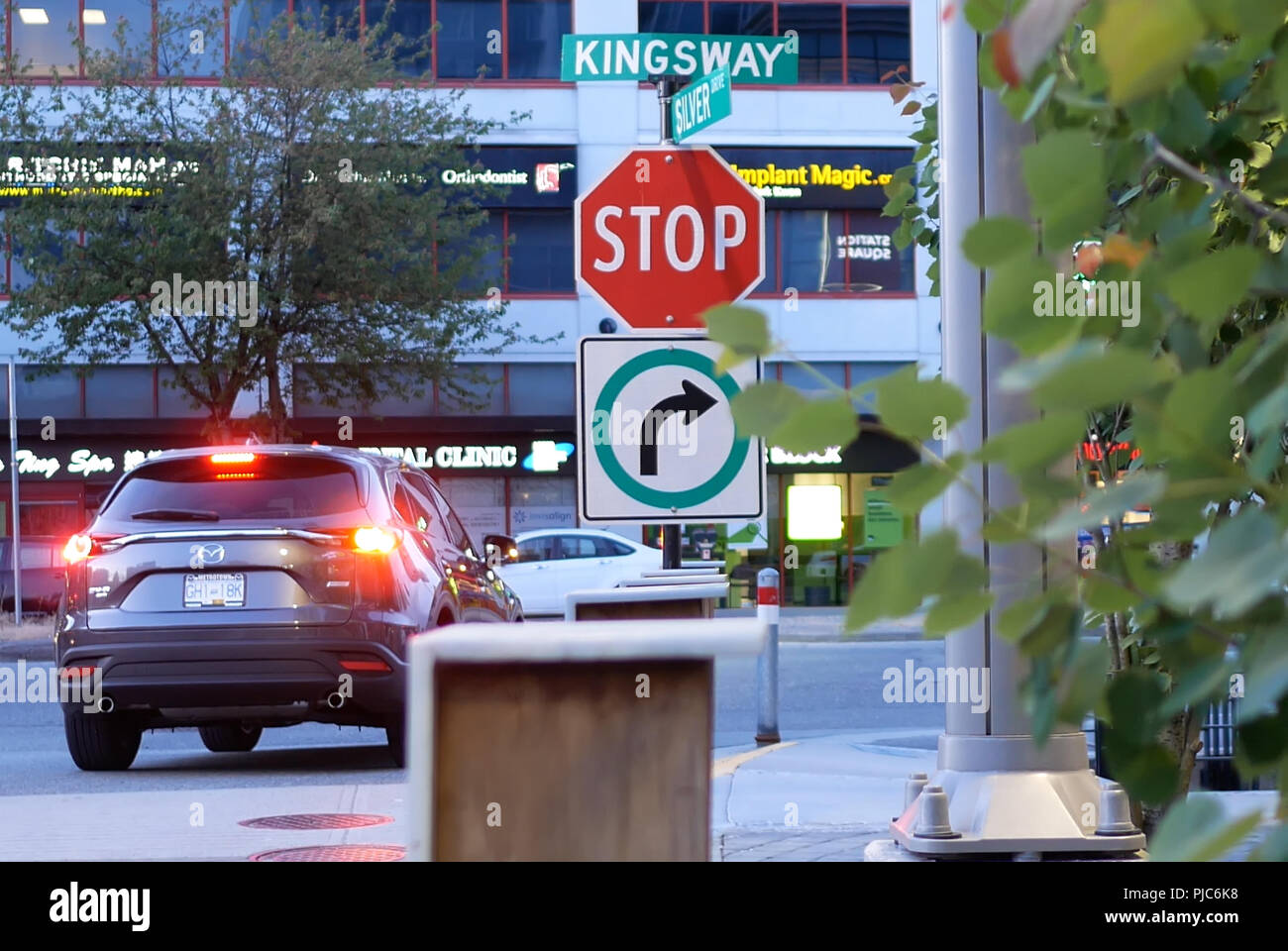 Burnaby, BC, Canada - le 30 mai 2018 : La motion du panneau d'arrêt sur le trottoir avec blur flux de trafic de Burnaby BC Canada Banque D'Images