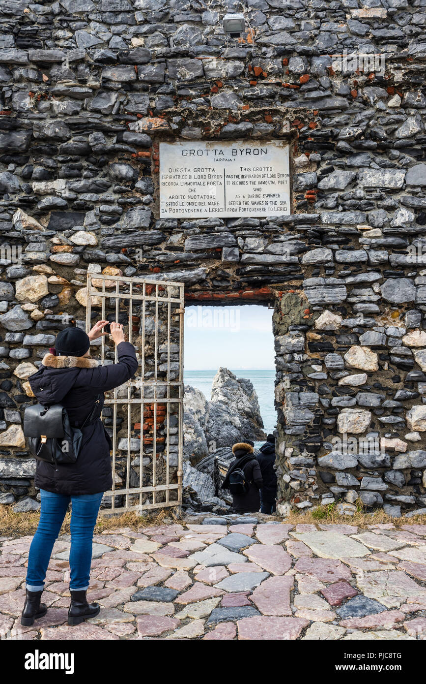 Tourist photographing 'Lord Byron's Grotto' entrée avec la porte et la plaque de marbre commémorative sur un vieux mur de pierre appartenant à château Doria, Portoven Banque D'Images