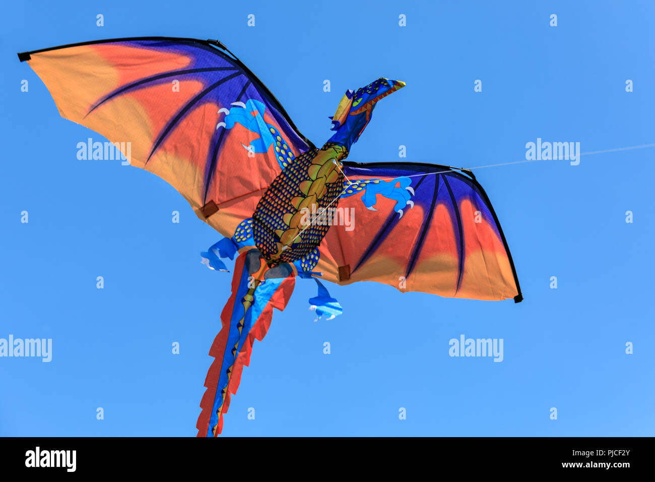 Un cerf-volant en forme de dragon contre ciel bleu profond Banque D'Images