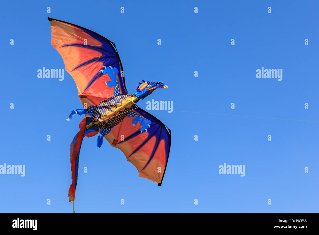 Un cerf-volant en forme de dragon contre ciel bleu profond Banque D'Images