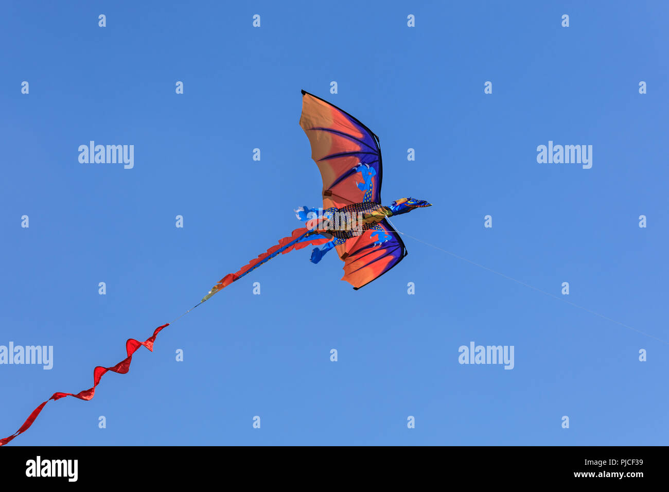 Un cerf-volant en forme de dragon contre ciel bleu profond Banque D'Images