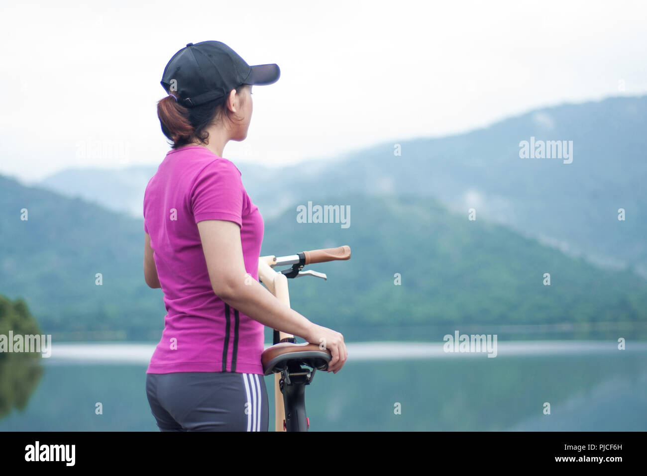 Sport asiatique fille debout à côté d'une bicyclette à la recherche et le view point Banque D'Images