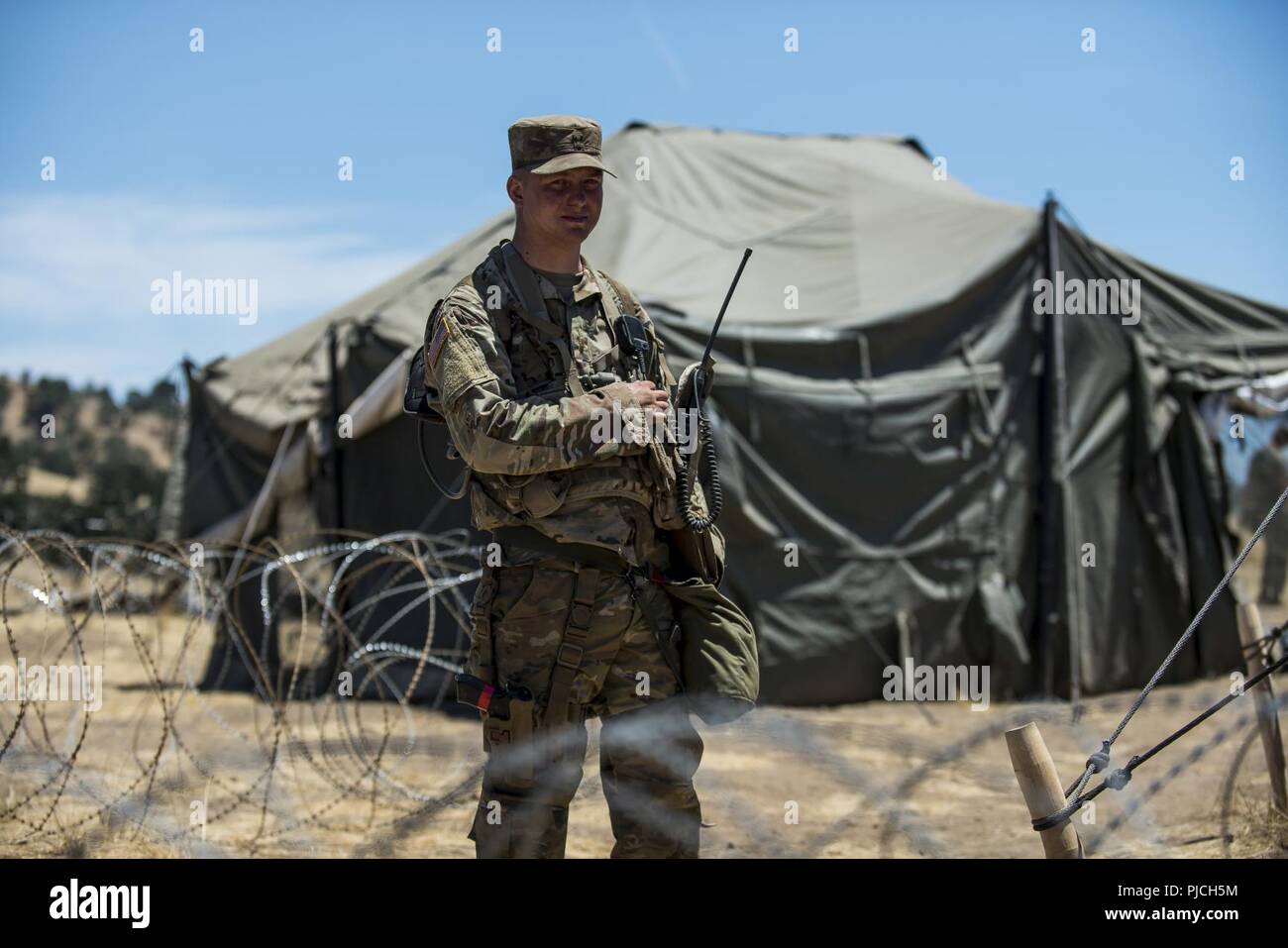 Deuxième Lieutenant Brian Krueger, un peloton de réserve de l'armée américaine chef dans le 348e Compagnie de Police Militaire, monte la garde en tant que soldats escort "ennemi prisonnier de guerre' par leur rôliste Theatre de détention au cours d'un exercice d'entraînement de soutien au combat (CSTX) à Fort Hunter Liggett, Californie, le 21 juillet 2018. Au cours de l'exercice, la police militaire sont responsables d'un centre de détention de théâtre aux processus et sécuriser jusqu'à 4 000 prisonniers de guerre ennemis et également gérer une zone de détention pour accueillir des civils déplacés. La police militaire a un vaste éventail de responsabilités au cours de la co Banque D'Images