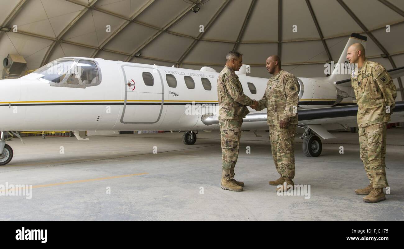 Le lieutenant général de l'ARMÉE AMÉRICAINE Michael X. Garrett, U.S. Army Central (USARCENT), général commandant de l'Armée américaine fait ses adieux au Sgt. Le major Michael Dotson avec l'UC-35 Jet, Détachement de la Compagnie Alpha, 6-52ème bataillon de l'Aviation après lui présentant une pièce à Ali Al Salem Air Base, le Koweït, le 21 juillet 2018. Le lieutenant général Garrett a visité la base aérienne pour remercier les membres de l'équipe de vol pour soutenir la mission de l'USARCENT de maintenir une présence durable dans les domaines de l'avant. Banque D'Images