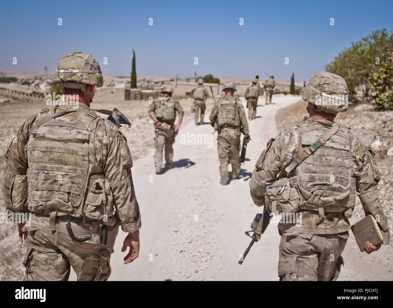 Les forces militaires américaines à pied vers leur prochain point de coordination indépendant au cours d'une patrouille, coordonnée le long de la ligne de démarcation en dehors de Manbij, Syrie, le 18 juillet 2018. Les États-Unis et l'armée turque conduite ces patrouilles pour aider à renforcer la sécurité et la stabilité dans la région de Manbij. Banque D'Images