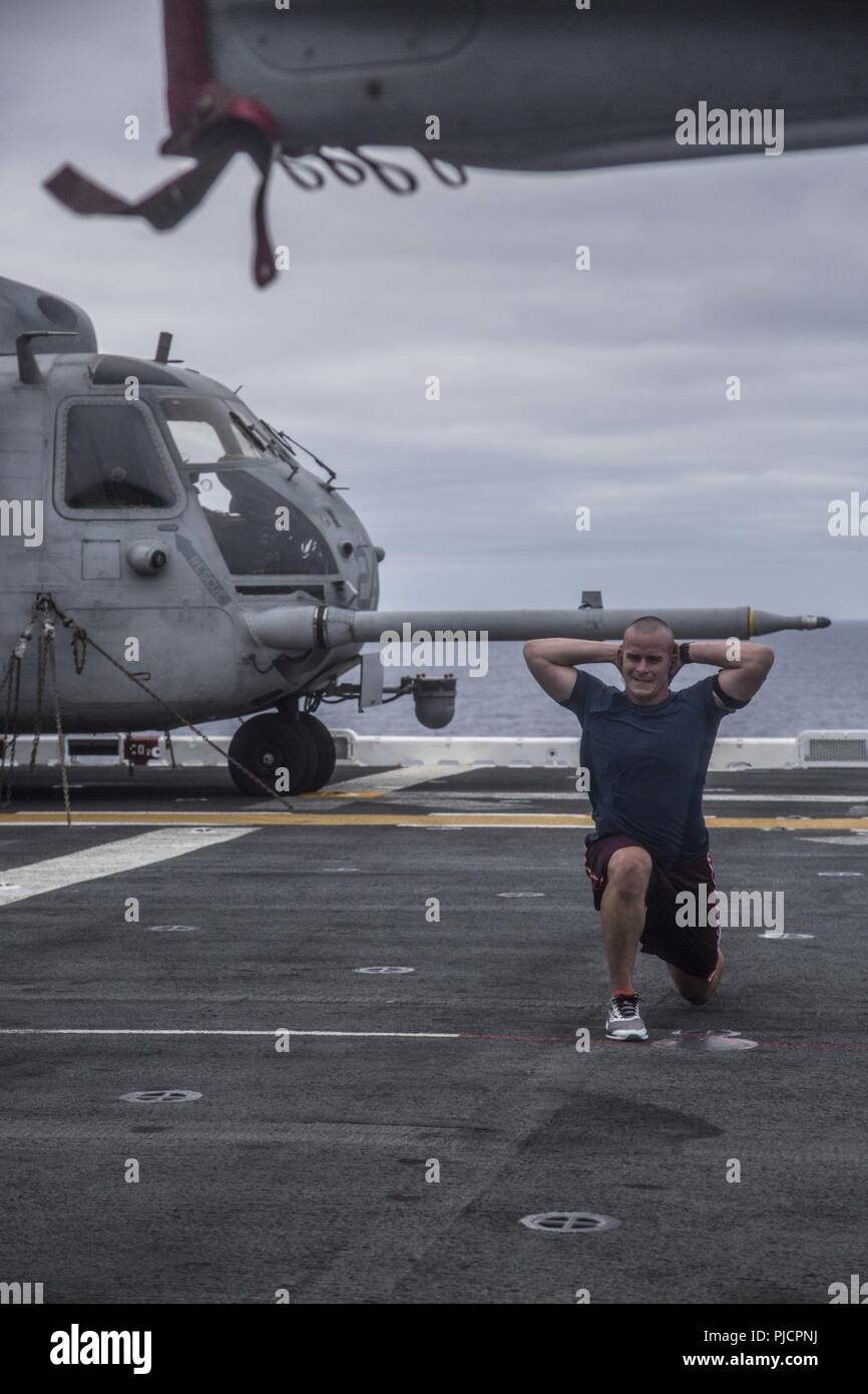 Océan Pacifique - U.S. Marine 1er lieutenant Ben Newman, commandant de peloton avec Lima Company, bataillon de l'équipe d'atterrissage 3/1, 13e Marine Expeditionary Unit (MEU), effectue l'entraînement physique sur le poste de pilotage de la classe Wasp-navire d'assaut amphibie USS Essex (DG 2) lors d'un déploiement prévu de la Essex Groupe amphibie (ARG) et la 13e MEU, le 13 juillet 2018. L'Essex ARG/MEU est une équipe solide, souple, réactive et cohérente capable de la guerre de manœuvre dans tous les domaines, il est équipé et évolutive pour répondre à n'importe quelle crise d'aide humanitaire et de relie Banque D'Images