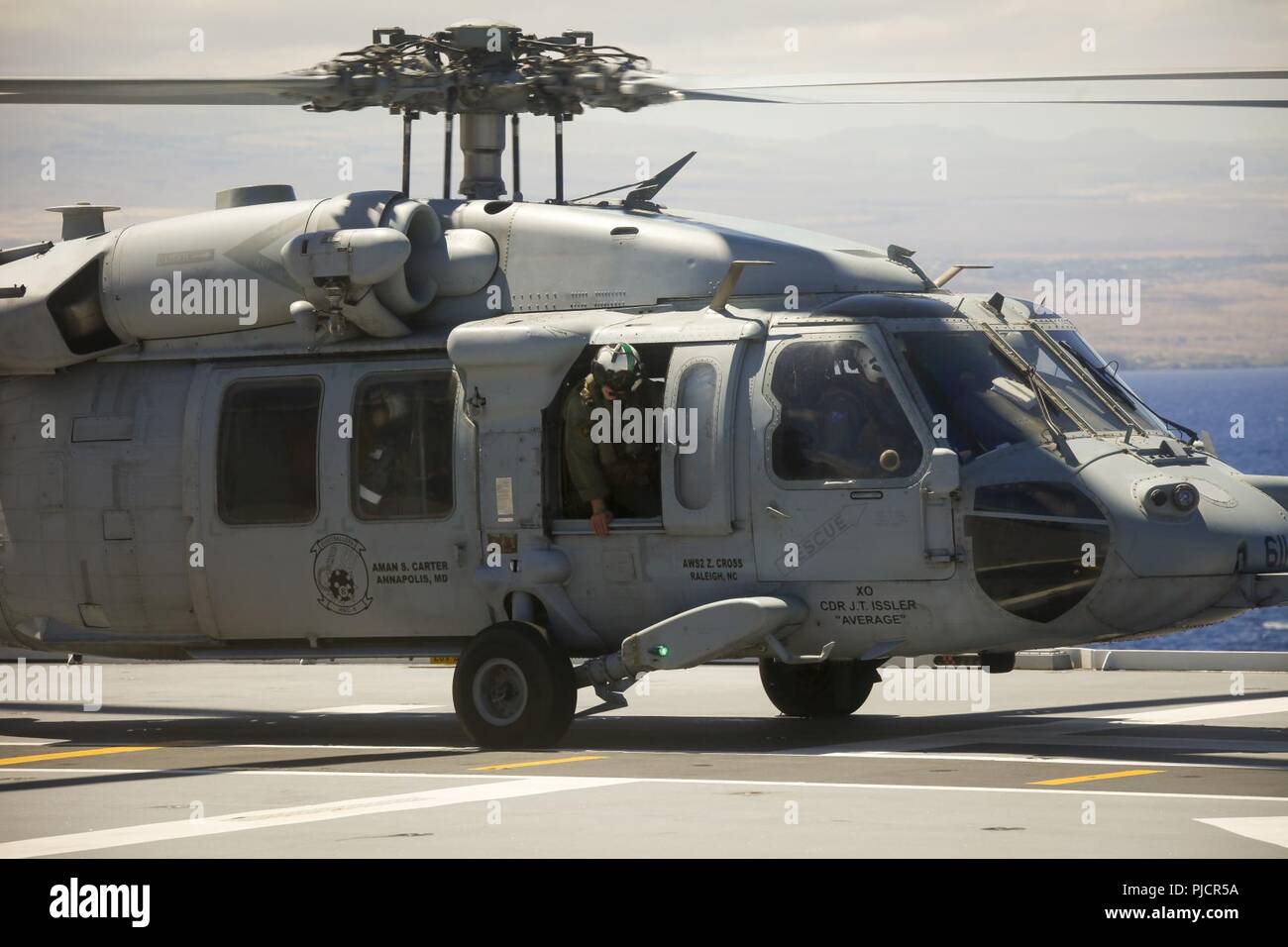 Le HMAS Adelaide une marine américaine Sikorsky SH-60 Seahawk chef d'équipe, avec l'Escadron d'hélicoptères de combat de la mer huit "Eightballers" vérifie auprès de la Marine royale australienne d'escale avant de retirer au cours de touche vers le bas des opérations à bord de la Royal Australian Navy landing helicopter dock navire HMAS Adelaide (L01) dans le cadre de l'exercice Rim of the Pacific (RIMPAC), le 22 juillet 2018. RIMPAC fournit une formation de valeur pour la tâche-organisé, très-capable Marine-Air Task Force au sol et améliore la capacité d'intervention de crise critique de Marines américains dans le Pacifique. Vingt-cinq nations, plus de 45 navires d'une Banque D'Images