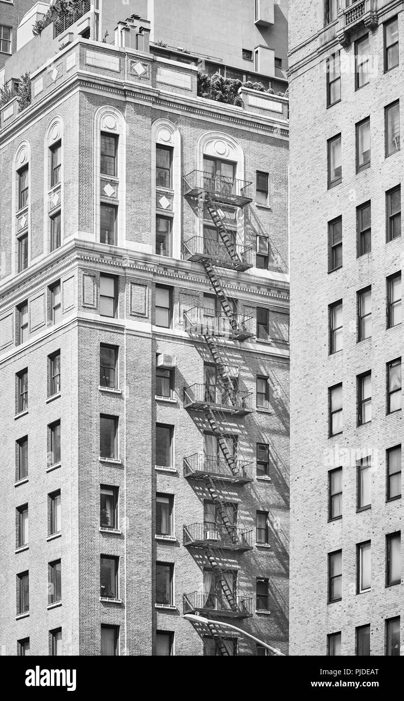 Photo noir et blanc d'un vieux bâtiment avec le feu s'échappe, New York City, USA. Banque D'Images