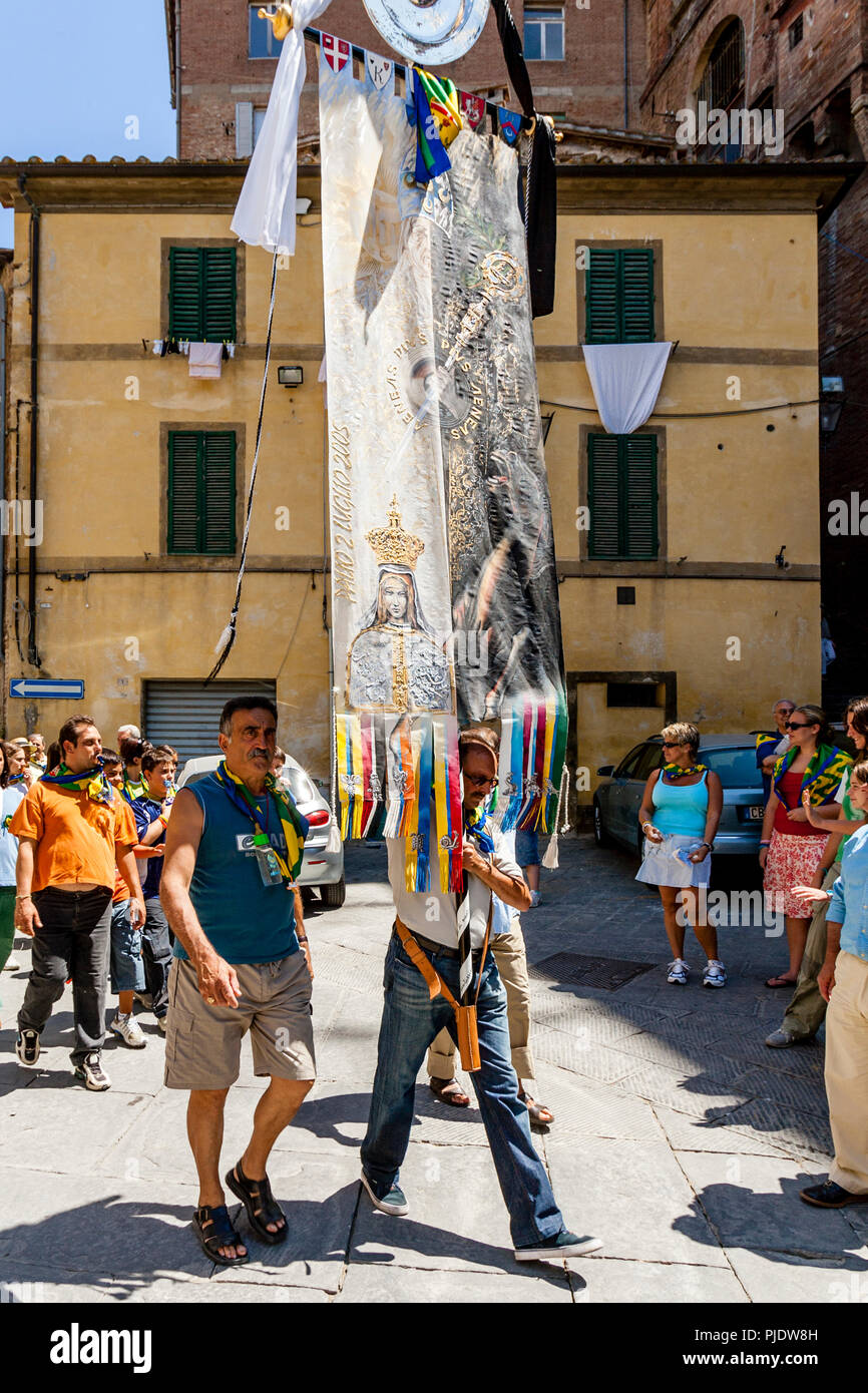 Membres de l'Équipe gagnante Bruco (Caterpillar) Contrada Parade leur prix  d'une bannière de soie dans les rues de Sienne, Palio di Siena, Sienne,  Italie Photo Stock - Alamy