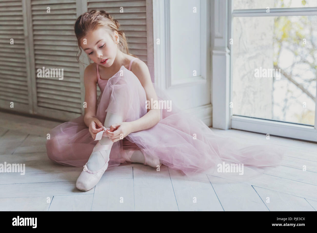 Jeune fille danseuse de ballet classique en cours de danse. Belle ballerine  en tutu rose gracieux jupe met sur les pointes près de grande fenêtre en  blanc lig Photo Stock - Alamy