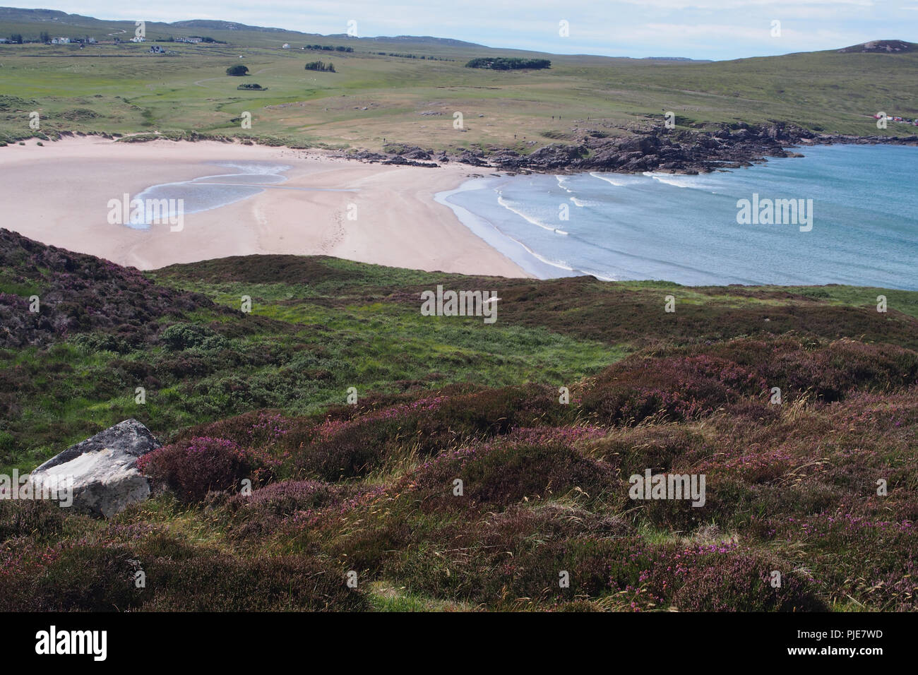 Vue à l'échelle d'Achnahaird beach, l'Écosse, de l'Orient avec les collines couvertes de bruyère dans l'avant-plan Banque D'Images