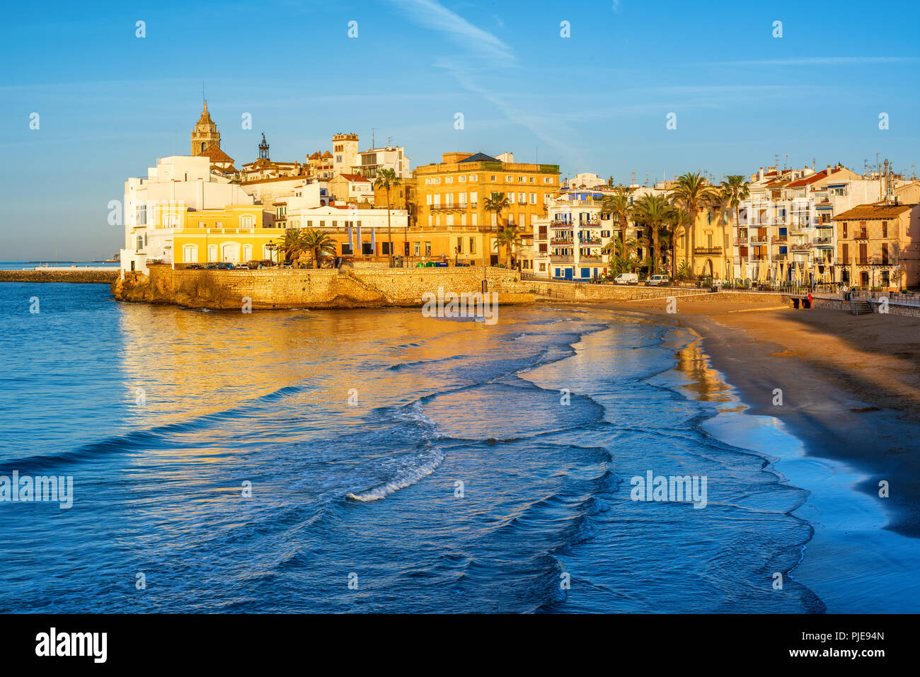 Plage de sable fin et sa vieille ville historique complexe méditerranéen à Sitges près de Barcelone, Costa Dorada, Catalogne, Espagne, au début de la lumière du matin Banque D'Images