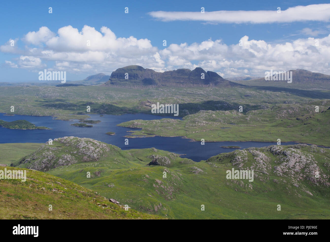 Vue à la Stac Pollaidh en face de la montagne à la montagne avec les lochs Suilven et terres en entre dans l'avant-plan et bleu ciel et nuages Banque D'Images